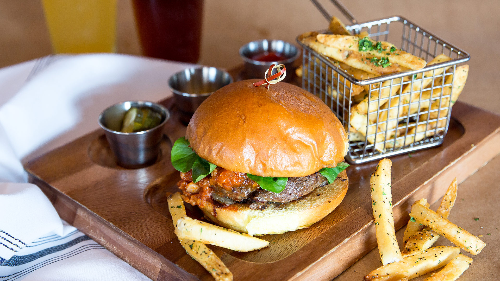 Burger and fries on wooden plate